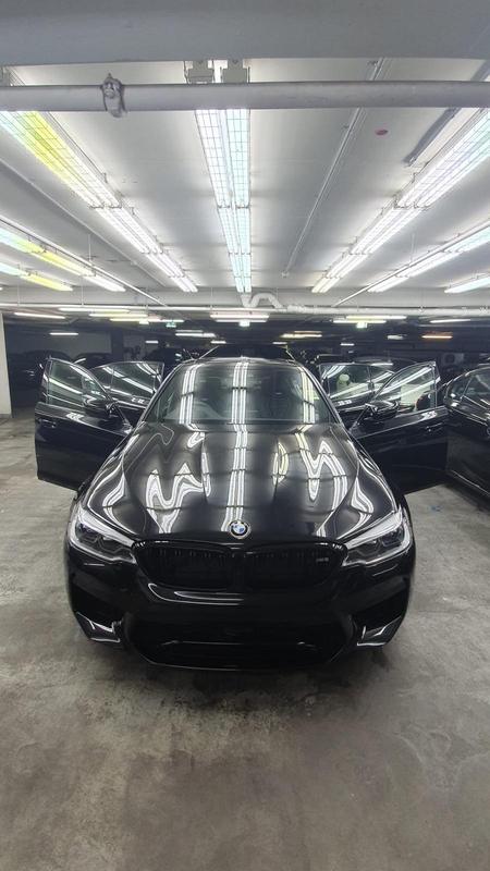 Black BMW M5 Competition with reflections on the bonnet